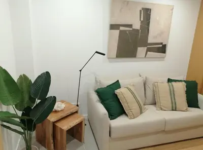 a living room with a white couch with green pillows at Casa Corisca - stylish, cosy, top location in the heart of Faro in Faro