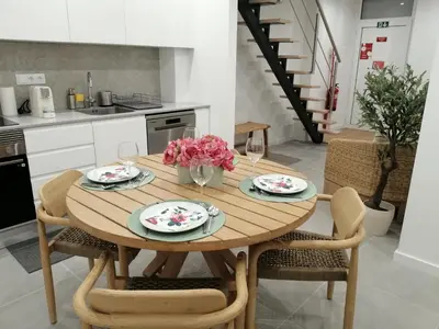 a kitchen with a wooden table with flowers on it at Casa Corisca - stylish, cosy, top location in the heart of Faro in Faro