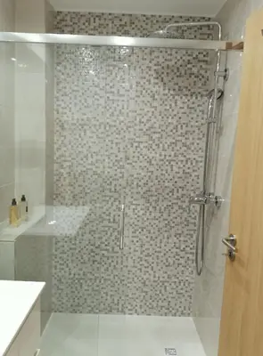 a bathroom with a shower with a glass door at Casa Corisca - stylish, cosy, top location in the heart of Faro in Faro