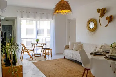 a living room with a couch and a table at Bright & Stylish 2bedflat 5min Walk to beach in Quarteira Vilamoura in Quarteira