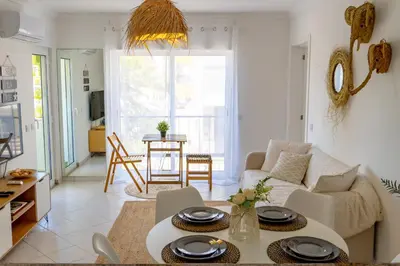 a living room with a couch and a table at Bright & Stylish 2bedflat 5min Walk to beach in Quarteira Vilamoura in Quarteira