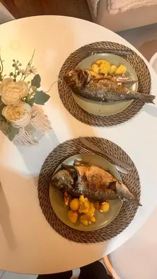 two plates of fish sitting on a table at Bright & Stylish 2bedflat 5min Walk to beach in Quarteira Vilamoura in Quarteira