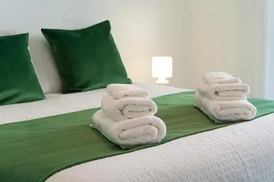 two stacks of towels sitting on a bed at Bright & Stylish 2bedflat 5min Walk to beach in Quarteira Vilamoura in Quarteira