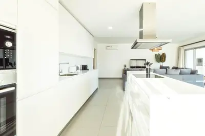 a kitchen with white cabinets and a counter top at The Green Escape Albufeira Poolside Retreat in Albufeira