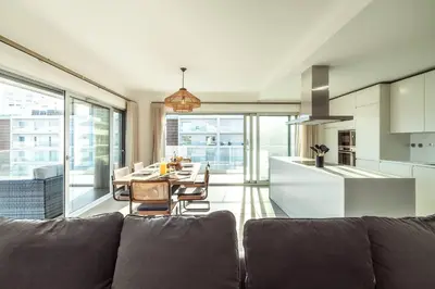 a living room with a couch and a table and a kitchen at The Green Escape Albufeira Poolside Retreat in Albufeira