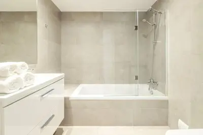 a white bathroom with a tub and a shower at The Green Escape Albufeira Poolside Retreat in Albufeira