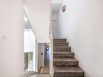 a staircase in a house with white walls and concrete floors at Villa Maria, 3BD & Pool & Garden & BBQ in Albufeira