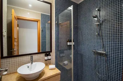 a bathroom with a sink and a shower with a mirror at Apartamento Vitoria in Vilamoura