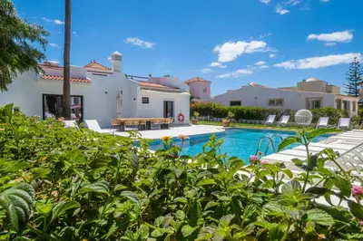a villa with a swimming pool and a house at Villa Veiga - Luxury modern design with large beautiful garden in Albufeira