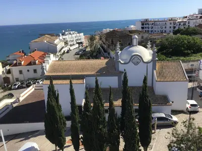 a white building with a clock on top of it at Old Town, Bay View Apartment in Albufeira