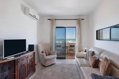 a living room with a couch and a flat screen tv at 1 Bedroom Seaview Apartment in Quarteira