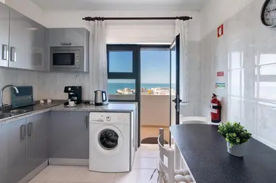 a kitchen with a washing machine in a kitchen at 1 Bedroom Seaview Apartment in Quarteira