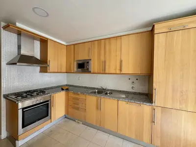 a kitchen with a table and a stove top oven at Albufeira Modern 7 With Pool by Homing in Albufeira