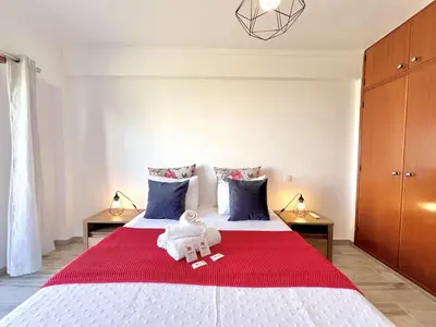 a bedroom with a large bed with a red blanket at Quarteira Brightness by Homing in Quarteira