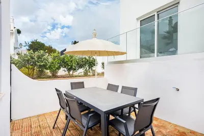 a dining room with a table and chairs and an umbrella at Casa Bella in Loulé