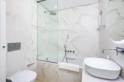 a white bathroom with a shower and a sink at Casa Bella in Loulé