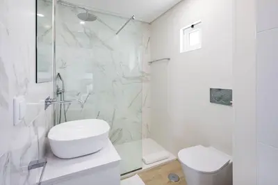 a white bathroom with a toilet and a shower at Casa Bella in Loulé