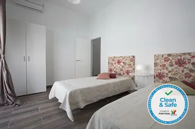 a bedroom with two beds and a sign that says clean and safe at DownTown Albufeira beach Apartment in Albufeira