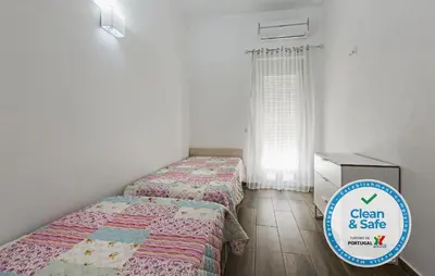 two beds in a bedroom with a sign that says clean and safe at DownTown Albufeira beach Apartment in Albufeira