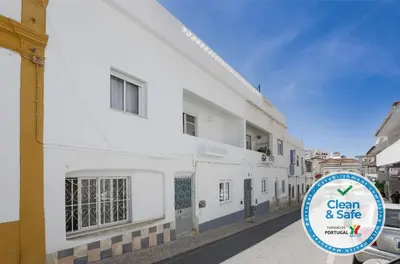 a sign in front of a white building at DownTown Albufeira beach Apartment in Albufeira