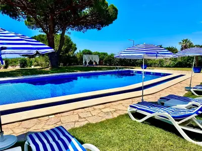 two chairs and umbrellas next to a swimming pool at SOLAR Do MONTE 2 in Albufeira