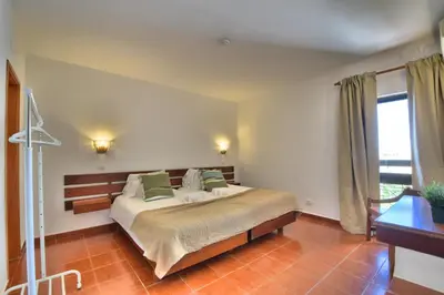 a bedroom with a large bed with green pillows at BeGuest Oura Vilanova Apartment in Albufeira