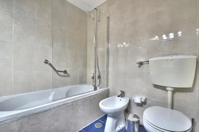 a bathroom with a toilet and a tub and a sink at BeGuest Oura Vilanova Apartment in Albufeira