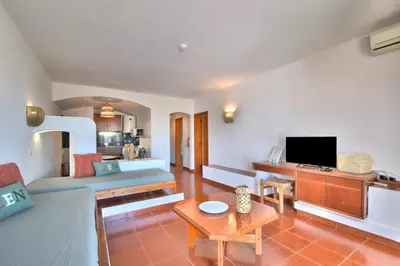 a living room with a couch and a tv at BeGuest Oura Vilanova Apartment in Albufeira