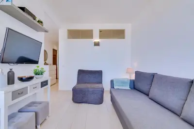 a living room with a couch and a tv at T1 Edificio Loulé - centro de Vilamoura in Vilamoura