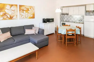 a living room with a couch and a table and a kitchen at BeGuest Sea Breeze Apartment in Albufeira