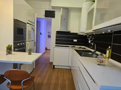 a kitchen with white cabinets and a blue door at Blife Batalya private rooms in Faro