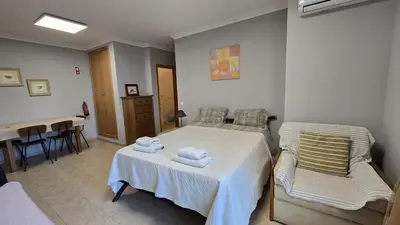 a bedroom with a bed and a table and chairs at Beautiful Studio Letícia in Roja- Pé