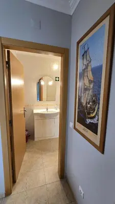 a bathroom with a painting of a ship on the wall at Beautiful Studio Letícia in Roja- Pé
