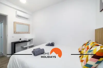 a bedroom with a bed with a home holidays sign on it at #304 - Albufeira Beach House by Home Holidays in Albufeira
