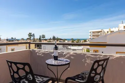 a bottle of wine sitting on a table on a balcony at Villa Terramar - Golden & Salty in Guia