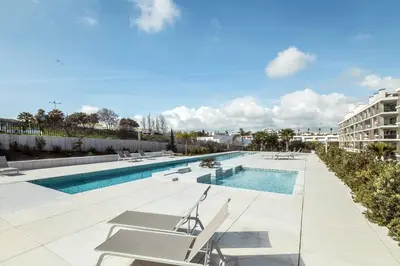 a swimming pool with lounge chairs and a building at Green View Studio with Pool in Albufeira
