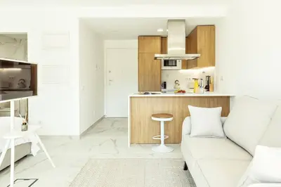 a living room with a couch and a kitchen at Green View Studio with Pool in Albufeira