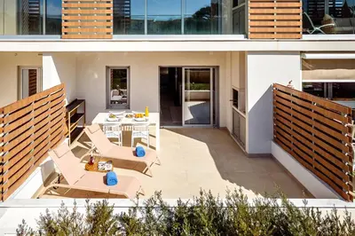a patio with chairs and tables on a house at Green View Studio with Pool in Albufeira