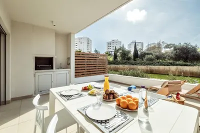 a kitchen and dining room with a table with food on it at Green View Studio with Pool in Albufeira