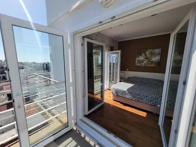 a bedroom with a bed and a balcony at Newly Remodeled 2BD Brilliant Oura Strip 9min beach in Albufeira