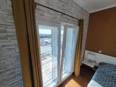 a bedroom with a large window with a brick wall at Newly Remodeled 2BD Brilliant Oura Strip 9min beach in Albufeira