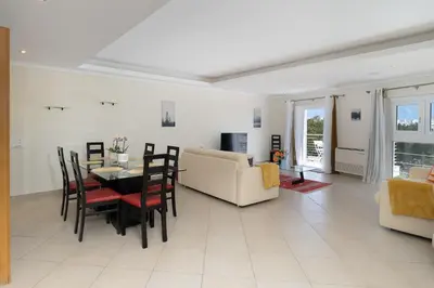 a dining room and living room with a table and chairs at Newly Remodeled 2BD Brilliant Oura Strip 9min beach in Albufeira