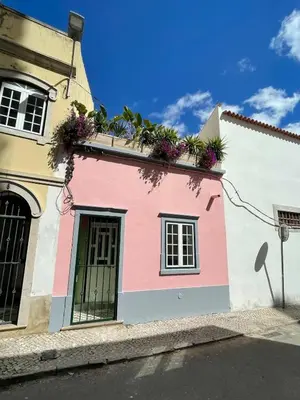 a white table with yellow chairs and plants at Arty city house Casa Da Selva in Faro