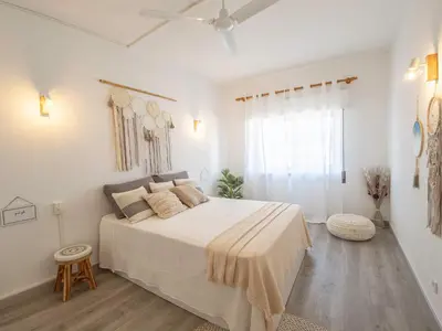a white bedroom with a large bed and a window at Boho house, Albufeira in Albufeira
