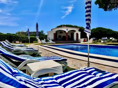 a group of lounge chairs next to a swimming pool at Villa SOLAR DO MONTE 3 in Albufeira