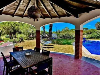 a patio with a table and chairs and a swimming pool at Villa SOLAR DO MONTE 3 in Albufeira