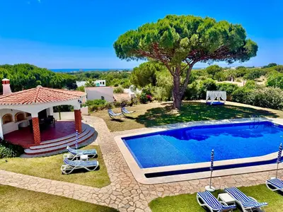a swimming pool in a yard with chairs and a gazebo at Villa SOLAR DO MONTE 3 in Albufeira