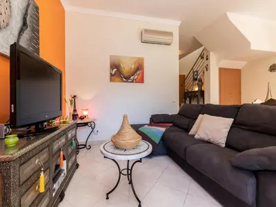 a living room with a couch and a flat screen tv at NEW! Villa Balaia K-11 in Branqueira