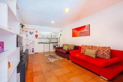 a living room with a red couch and a table at Apartment Milos by Algarve Vacation in Albufeira