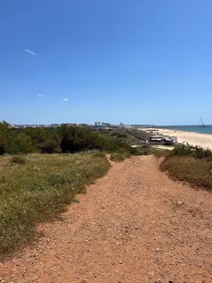 a dirt road next to the ocean on a beach at Sea-Stretch viewing SuperKing flat by BentoBox in Albufeira
